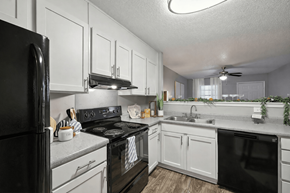 Mooresville apartment for rent - A black stove top oven sits in a kitchen with white cabinets.