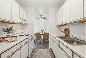 Chaska apartment for rent - A kitchen with white cabinets and a dining table with chairs.