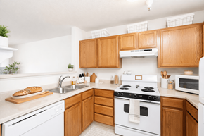 Hilliard apartment for rent - A kitchen with a white stove top oven and wooden cabinets.