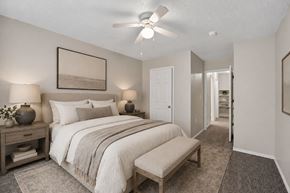 Dallas townhouse for rent - A bedroom with a large bed and a ceiling fan.