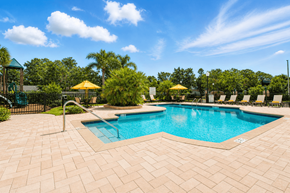 Fort Myers apartment for rent - A large outdoor swimming pool surrounded by a brick patio.