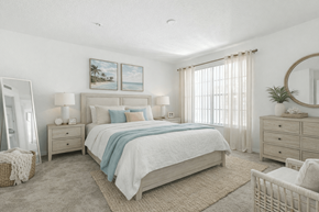 Jacksonville apartment for rent - A bedroom with a large bed, a mirror, and a painting on the wall.