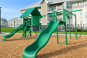 Bluffdale townhouse for rent - A green playground slide in front of apartment buildings.