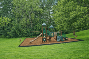 Chaska apartment for rent - A playground with a green slide and a red swing set.
