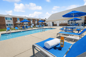 Cudahy apartment for rent - A sunny day at the pool with blue loungers and umbrellas.