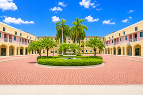 Lauderdale Lakes apartment for rent - A courtyard with a fountain surrounded by palm trees and buildings.