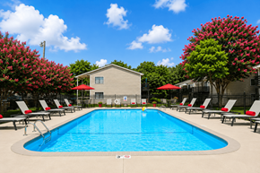 Mooresville apartment for rent - A pool surrounded by red umbrellas and lounge chairs.