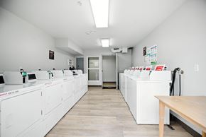 Huntington Beach apartment for rent - A clean, white-walled room with a row of white appliances and a wooden table.