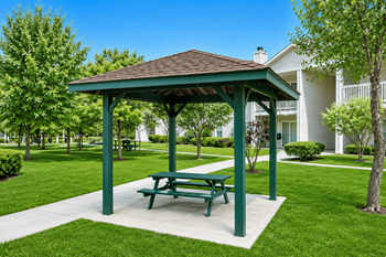 Green pavilion with picnic bench on concrete pad