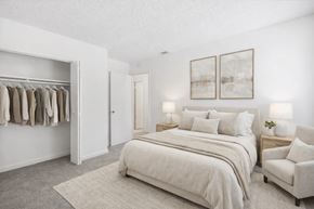 Decatur townhouse for rent - A bedroom with a large bed, a chair, and a wardrobe.