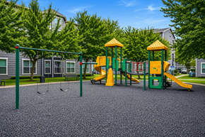 Houston apartment for rent - A playground with a yellow and green slide and a green and yellow swing set.