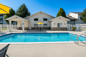 Brigham City apartment for rent - A swimming pool in front of a house with a yellow umbrella.