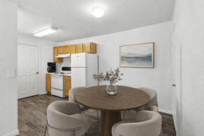 Spanish Fork apartment for rent - A kitchen with a refrigerator, a dining table with chairs, and a painting on the wall. at Diamond Fork Apartments, Spanish Fork, Utah