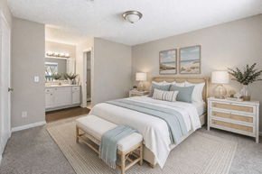 Orange Park apartment for rent - A bedroom with a large bed and a dresser. at Parkland at Orange Park Apartments , Orange Park, Florida
