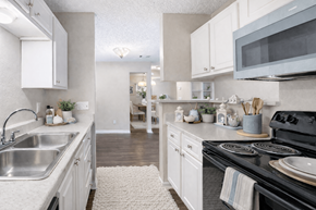Orange Park apartment for rent - A kitchen with white cabinets and a black stove top. at Parkland at Orange Park Apartments , Orange Park
