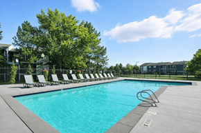 West Valley City apartment for rent - A swimming pool surrounded by trees and chairs.