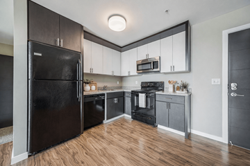 Richland apartment for rent - A black refrigerator is in a kitchen with wooden floors.