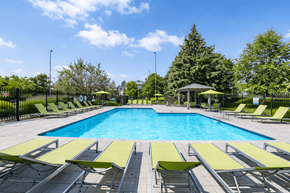 Burnsville apartment for rent - A large swimming pool surrounded by sun loungers and trees.