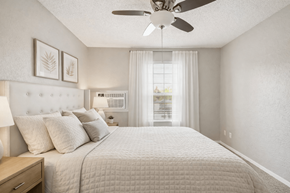 Burnsville apartment for rent - A bedroom with a large bed and a ceiling fan.