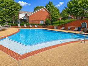 Dallas townhouse for rent - A pool surrounded by a brick border and lounge chairs.