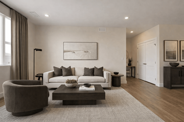 Denver apartment for rent - A modern living room with a grey sofa, a brown armchair, a coffee table, and a large painting on the wall.