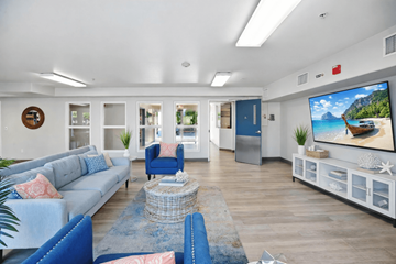 Huntington Beach apartment for rent - A living room with a grey sofa and a blue armchair.