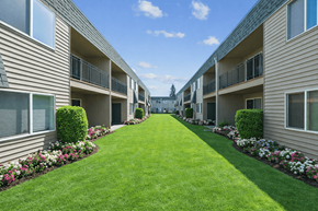 Vancouver townhouse for rent - A long row of apartment buildings with green lawns in between.