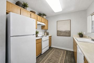 Sacramento apartment for rent - A kitchen with a white refrigerator and wooden cabinets.