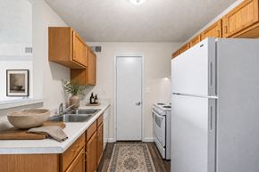 Portsmouth apartment for rent - A kitchen with a white refrigerator and wooden cabinets.