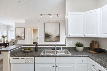 Atlanta apartment for rent - A modern kitchen with white cabinets and a granite countertop.