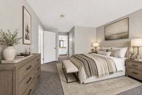 Saginaw apartment for rent - A bedroom with a large bed and a dresser with a vase on top.