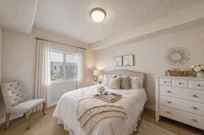 South Jordan apartment for rent - Bedroom with tufted chair and white dresser at The Beckstead Apartments, South Jordan
