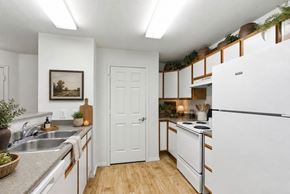 Provo apartment for rent - A kitchen with white appliances and wooden floors at Slate Canyon Apartments, Utah, 84606