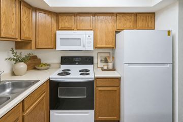 West Bountiful apartment for rent - A kitchen with wooden cabinets and a white refrigerator.