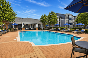 Houston apartment for rent - A swimming pool surrounded by a brick patio and lounge chairs.