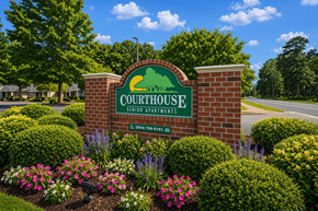 Chesterfield apartment for rent - A sign for Courthouse Senior Apartments is surrounded by flowers and greenery.