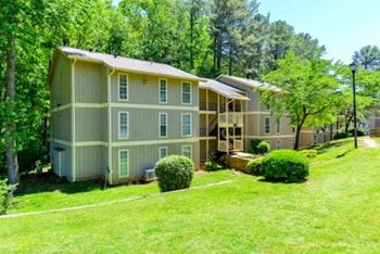 Three story apartment building with landscaped grounds