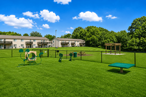 Mooresville apartment for rent - A playground area with a green slide, a green bench, and a green trampoline.