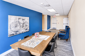Layton apartment for rent - Community meeting room with dining table and artwork at The Ellison Apartments, Layton, Utah
