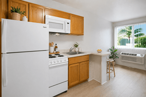 Huntington Beach apartment for rent - A kitchen with white appliances and wooden cabinets.