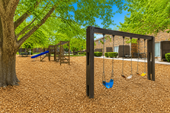 Swing set and play equipment under mature trees