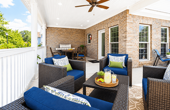 Covered porch with wicker furniture and blue cushions