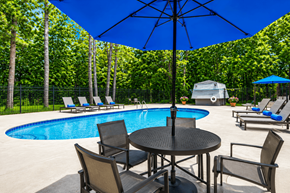 Jonesboro apartment for rent - A pool area with a table and chairs and an umbrella.