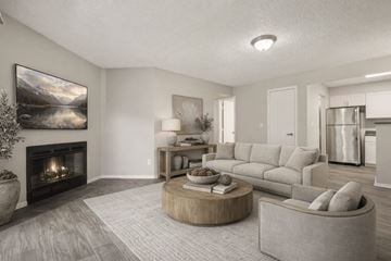Arvada apartment for rent - A modern living room with a fireplace and a large painting on the wall.