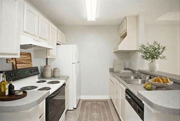 Newnan townhouse for rent - A kitchen with white cabinets and a black stove top.