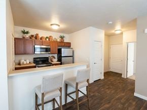 Salt Lake City apartment for rent - A kitchen with a white counter and brown chairs.