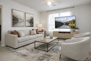 Stone Mountain apartment for rent - A living room with a couch, chairs, a coffee table, and a television displaying a mountain landscape.