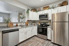 Los Alamos apartment for rent - A modern kitchen with stainless steel appliances and white cabinets.
