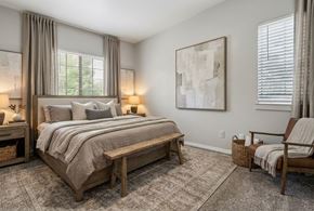 Los Alamos apartment for rent - A bedroom with a large bed and a bench.