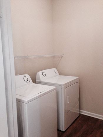 Two washer and dryers in a room with a door